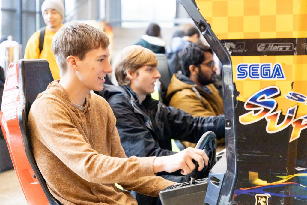 students playing a car arcade game