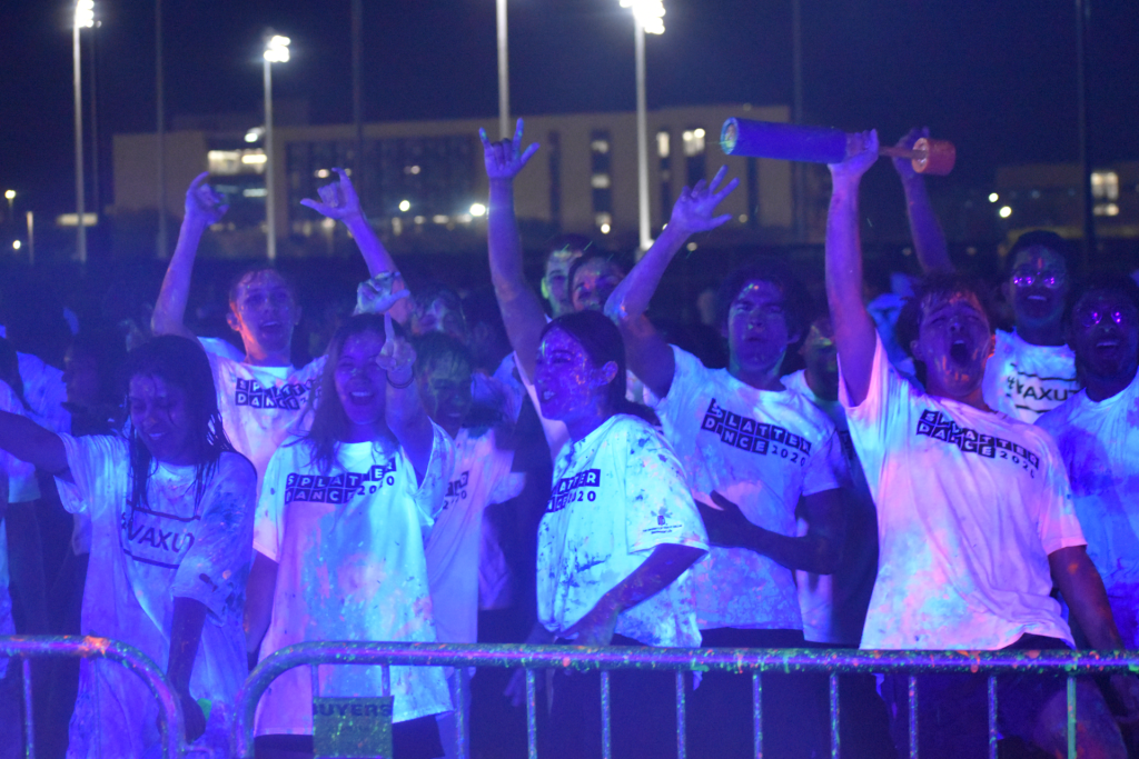 Students in white shirts covered in glow paint